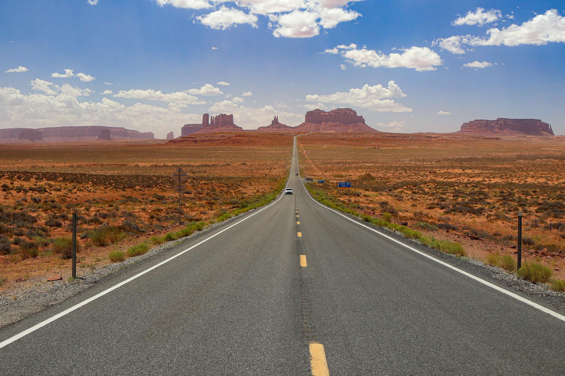 Pusta szosa w Monument Valley prowadząca przez pustynny krajobraz Pusta szosa w Monument Valley prowadząca przez pustynny krajobraz